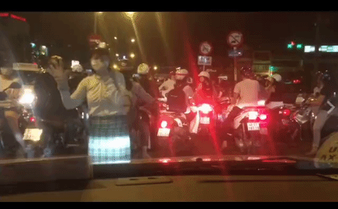 Người phụ nữ đội mũ bảo hiểm, đeo khẩu trang và hành động lạ giữa phố