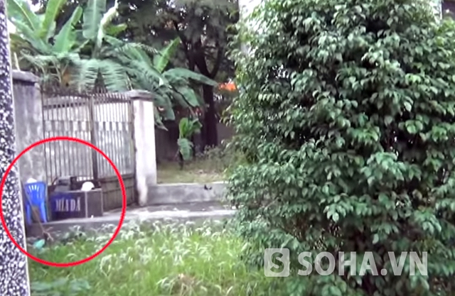 Một máy xay nước mía cùng ghế nhựa được cất gọn sau cánh cổng phụ của căn nhà