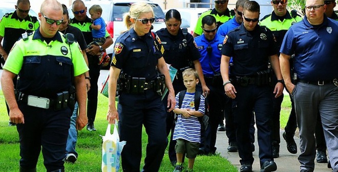 Câu chuyện buồn đằng sau bức hình em bé 4 tuổi đi khai giảng với 18 cảnh sát theo sau