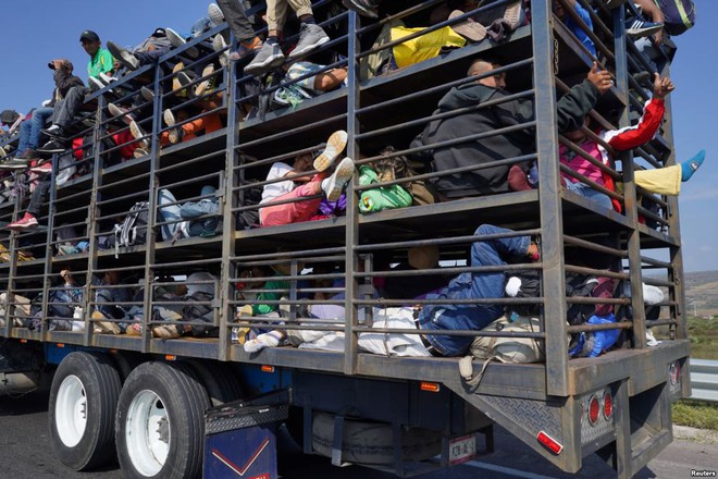 24h qua ảnh: Người di cư ngồi trên xe tải chở gà để tới biên giới Mỹ - Ảnh 2.