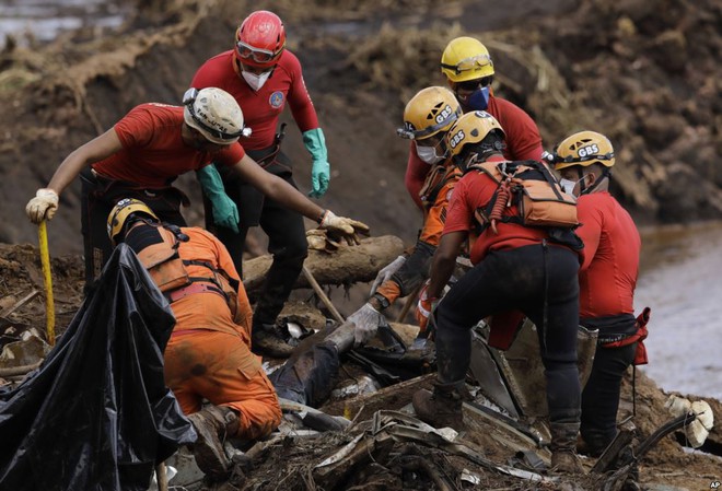24h qua ảnh: Nhân viên cứu hộ kéo xác người trong thảm họa vỡ đập - Ảnh 2.