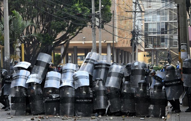 24h qua ảnh: Xe quân sự chạy qua người biểu tình trên đường phố Caracas - Ảnh 8.