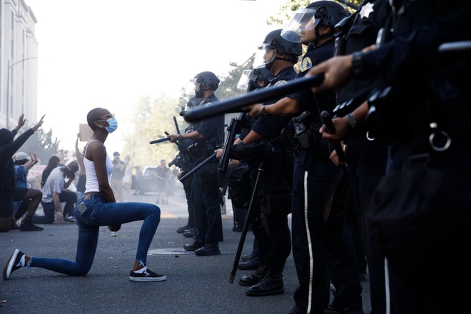24h qua ảnh: Người biểu tình quỳ trước cảnh sát chống bạo động ở Mỹ - Ảnh 2.
