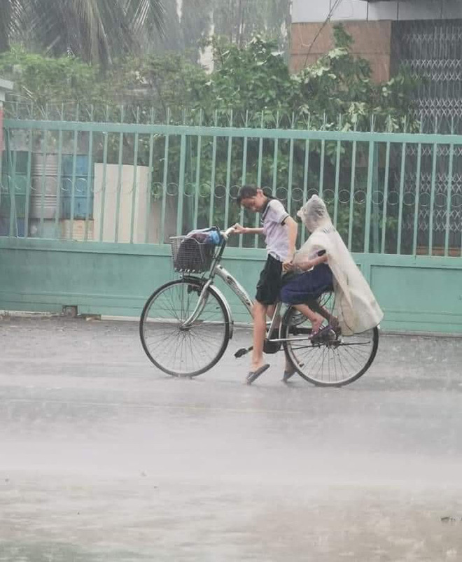 Mưa to vẫn nhường hết áo mưa cho em trai, cô học trò còn làm hành động cưng xỉu thu về 10.000 like - Ảnh 1.