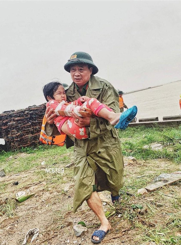 Khoảnh khắc chiến sĩ công an bế bé gái gãy tay vội vã lên ô tô tới bệnh viện trong cơn mưa lũ Quảng Bình gây xúc động - Ảnh 1.