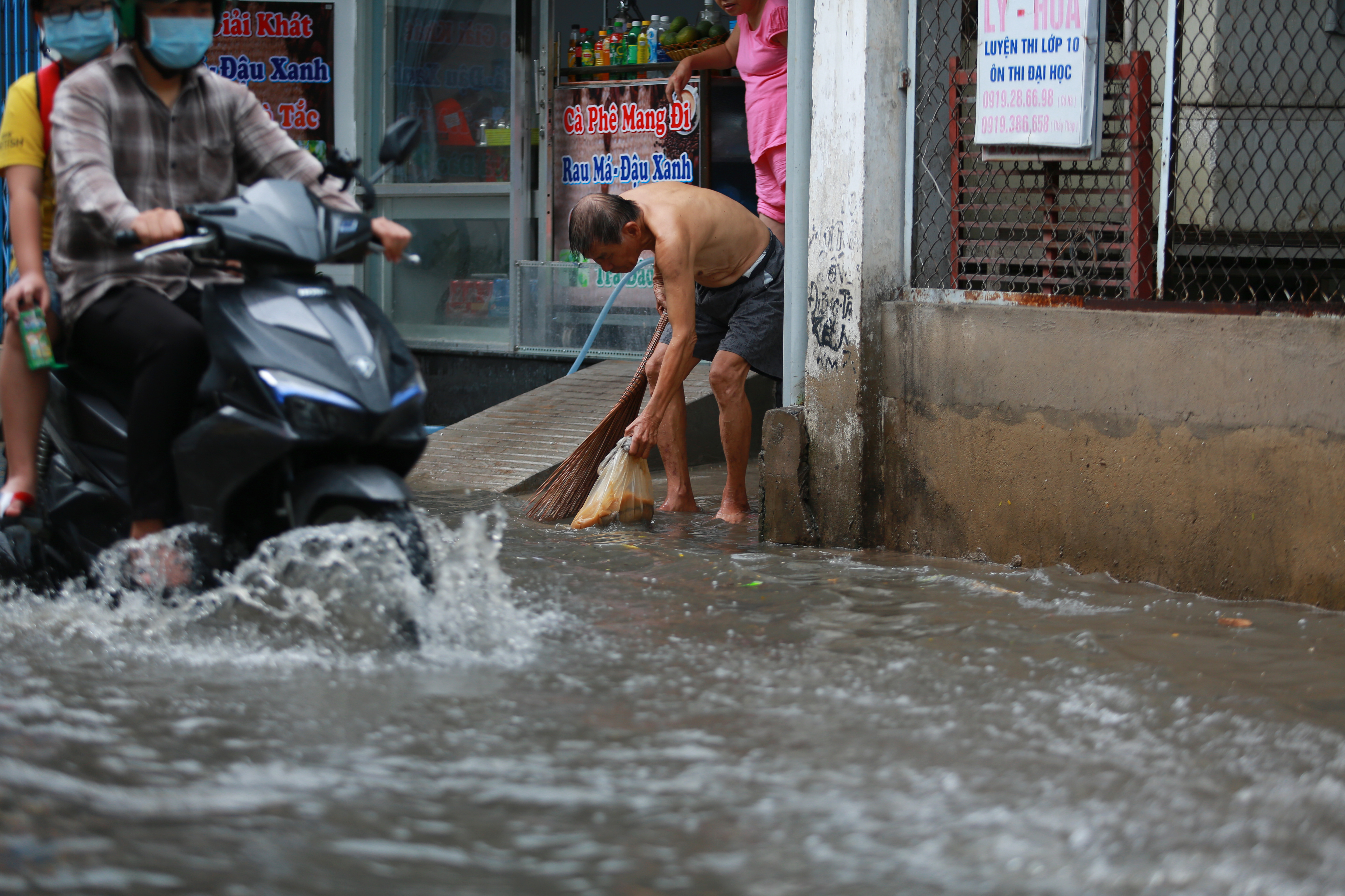 [ẢNH] Nước chảy xiết kéo nhiều xe máy đổ nhào giữa phố Sài Gòn, người dân dắt bộ cho an toàn - Ảnh 11.