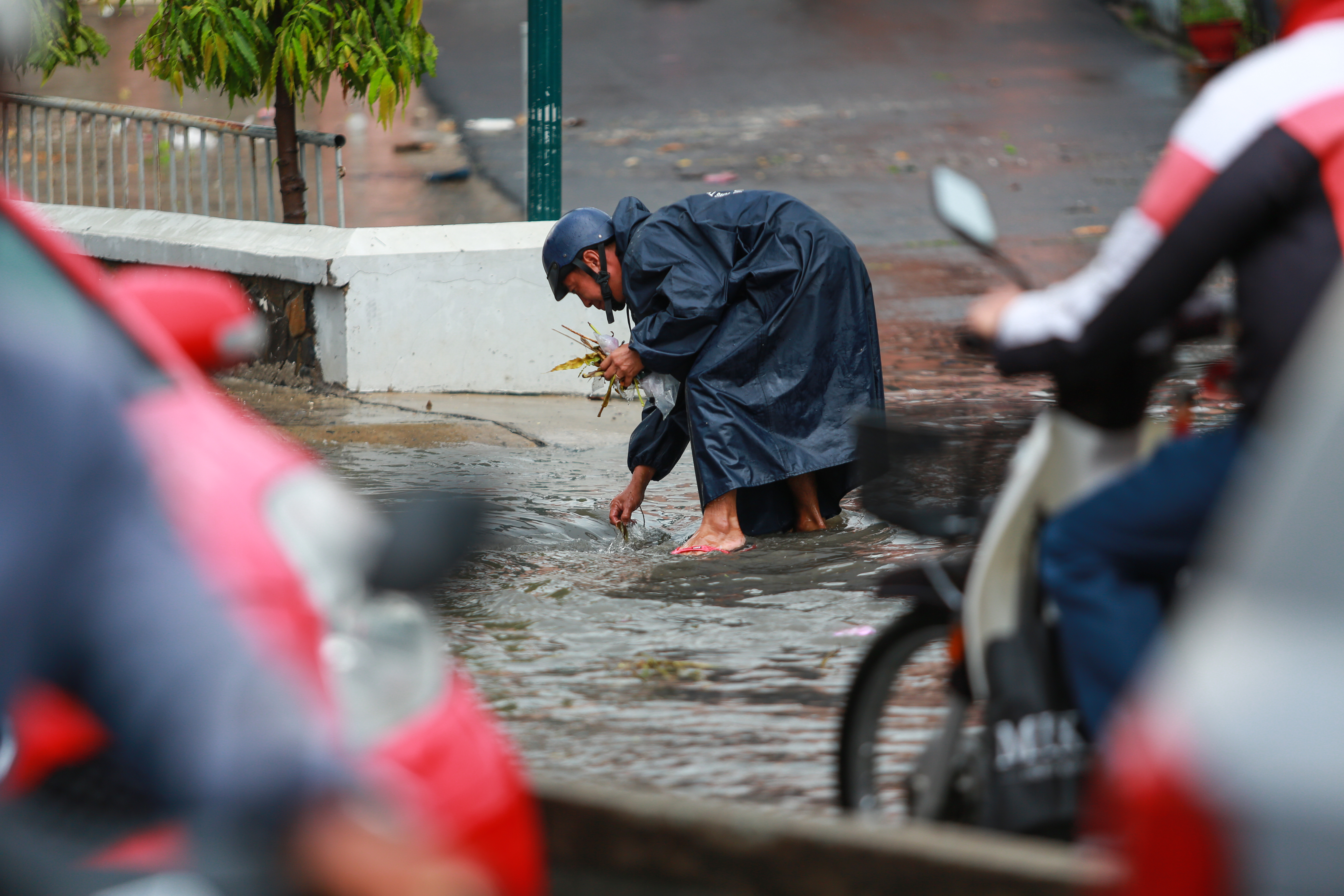 [ẢNH] Nước chảy xiết kéo nhiều xe máy đổ nhào giữa phố Sài Gòn, người dân dắt bộ cho an toàn - Ảnh 9.