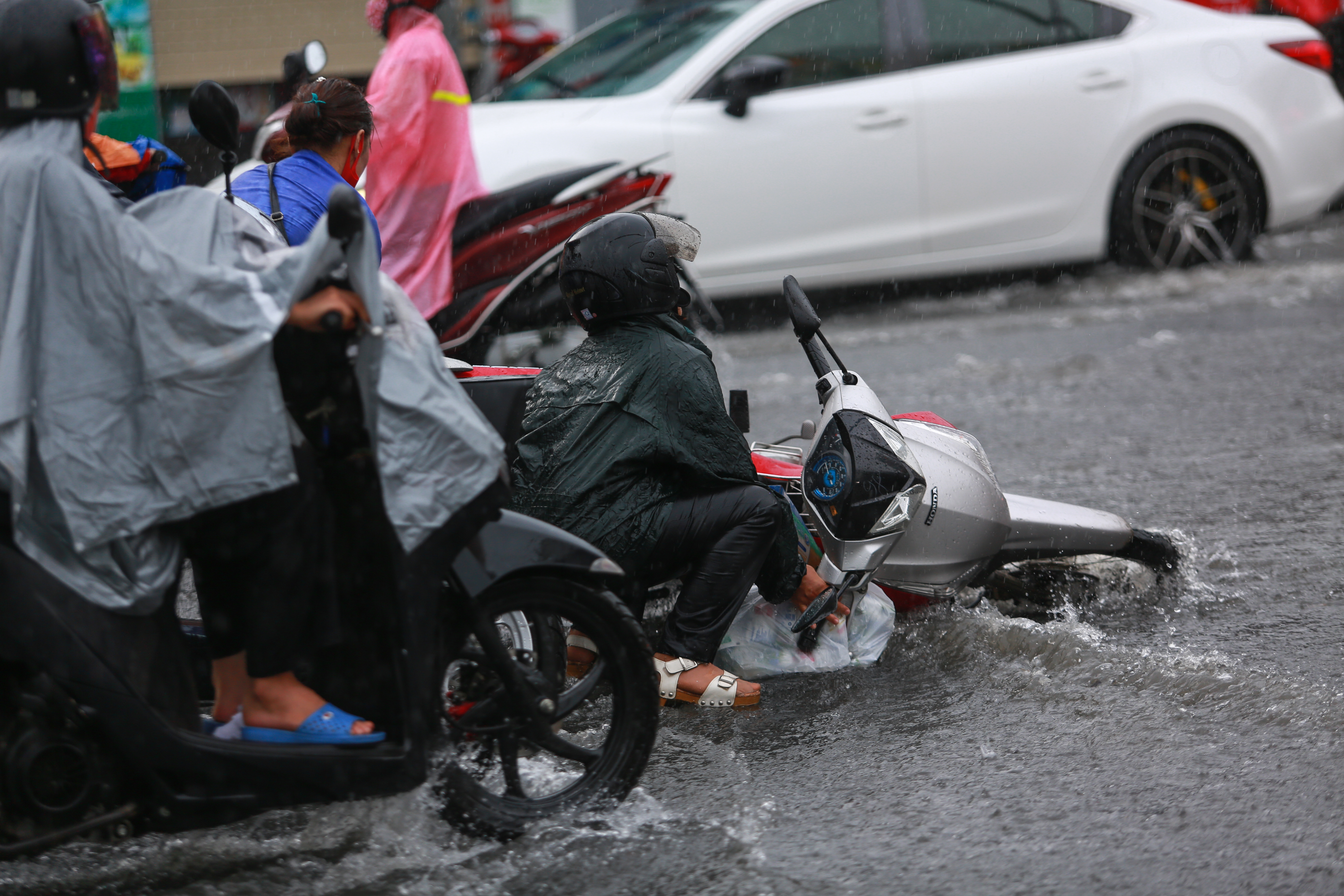 [ẢNH] Nước chảy xiết kéo nhiều xe máy đổ nhào giữa phố Sài Gòn, người dân dắt bộ cho an toàn - Ảnh 3.