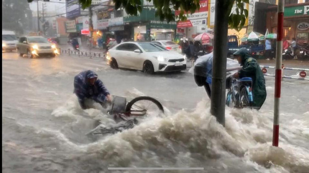 Thót tim cảnh học trò bất chấp đạp xe về nhà giữa lúc mưa bão, bị nước cuốn trôi; cặp sách, xe đạp văng xa cả mét - Ảnh 1.