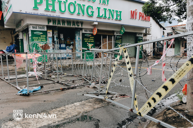 Người Sài Gòn chui hàng rào thép gai để giao hàng vì chốt chặn một số nơi chưa được tháo gỡ - Ảnh 1.