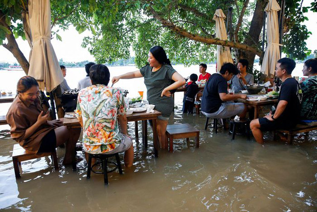 Nhà hàng “tranh thủ” nhất mùa lũ: Nước ngập quá đầu gối vẫn mở cửa, khách vừa ăn vừa “nhảy sóng” - Ảnh 1.