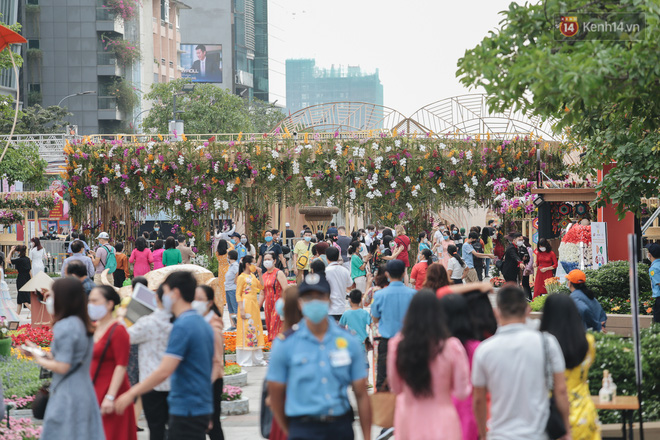 Ảnh: Người Sài Gòn xếp hàng đo thân nhiệt, đeo khẩu trang vào check in đường hoa Nguyễn Huệ - Ảnh 5.