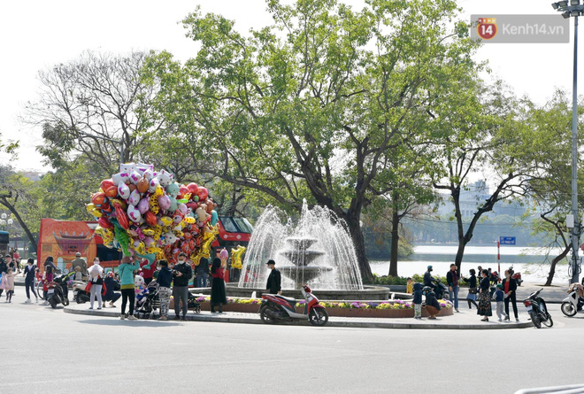 Người dân Thủ đô đổ lên hồ Gươm chụp ảnh, tận hưởng không khí náo nhiệt ngày 30 Tết - Ảnh 1.