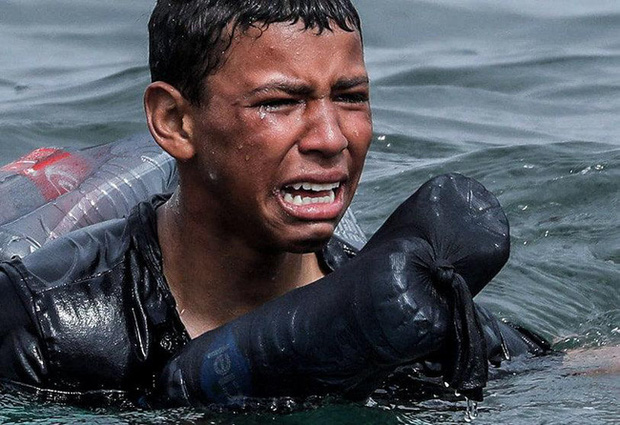 Khoảnh khắc cậu bé di cư bật khóc giữa biển nước mênh mông, dùng chai nhựa để bơi đến miền đất hứa gây chấn động thế giới - Ảnh 3.