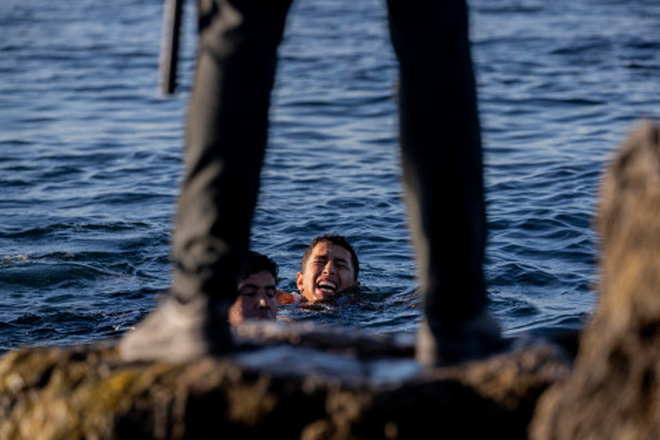 Khoảnh khắc cậu bé di cư bật khóc giữa biển nước mênh mông, dùng chai nhựa để bơi đến miền đất hứa gây chấn động thế giới - Ảnh 8.