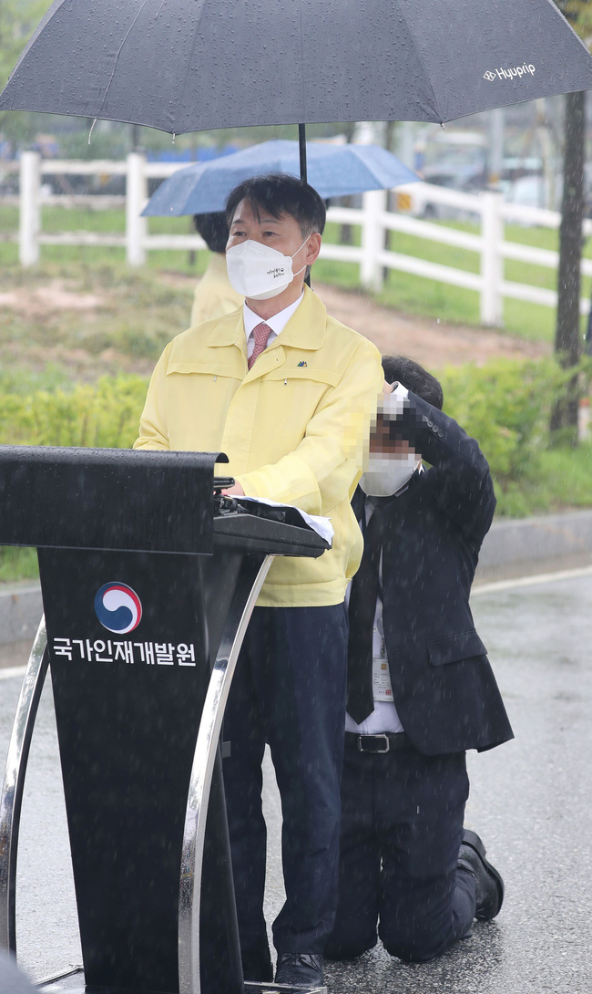 Nhân viên quỳ gối dưới mưa suốt 10 phút để che ô cho Thứ trưởng Hàn Quốc, truyền thông đồng loạt tiết lộ clip ghi lại sự việc - Ảnh 2.