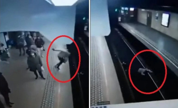 Video: Người phụ nữ bị đẩy thẳng xuống đường ray khi tàu đang lao tới, camera ghi lại khoảnh khắc 10 giây đứng tim gây sốc - Ảnh 2.