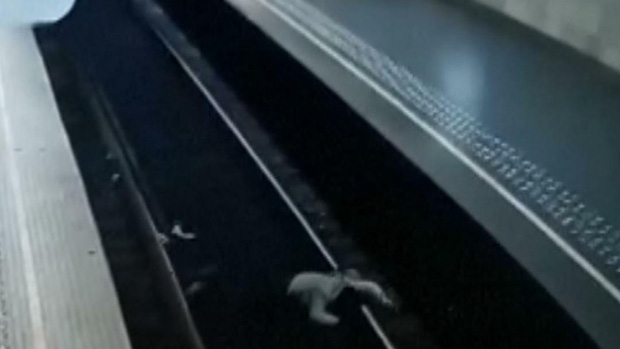 Video: Người phụ nữ bị đẩy thẳng xuống đường ray khi tàu đang lao tới, camera ghi lại khoảnh khắc 10 giây đứng tim gây sốc - Ảnh 3.