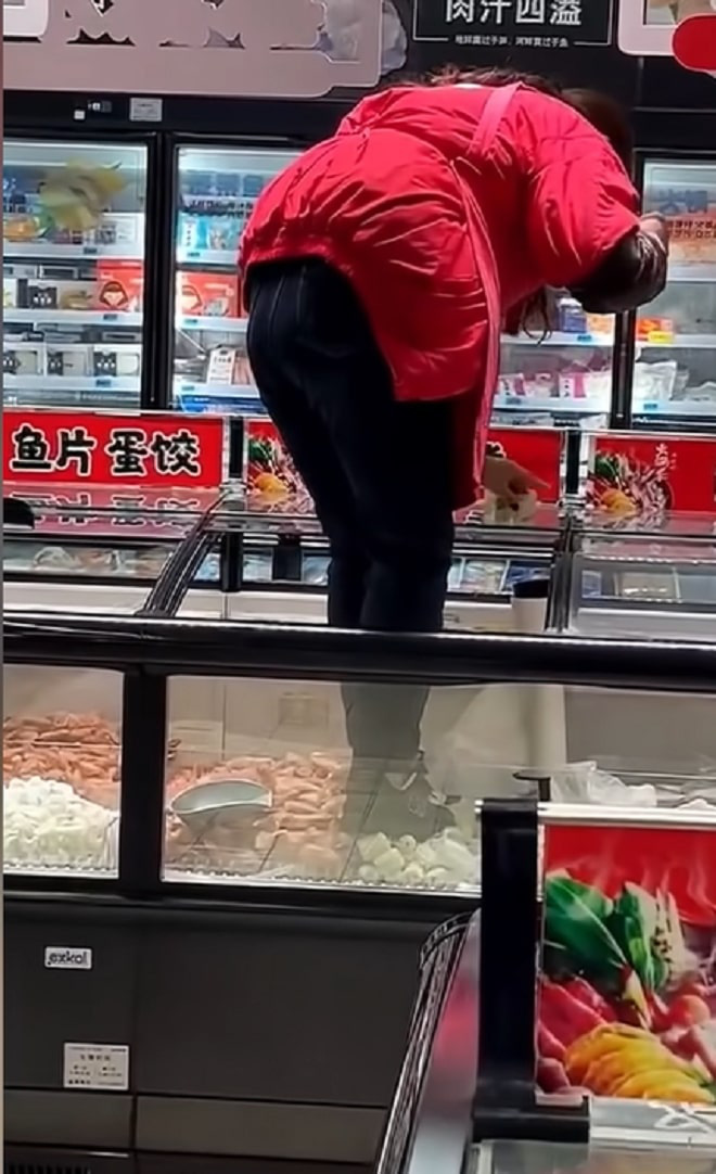 Nữ nhân viên ở siêu thị Trung Quốc khiến dân mạng phẫn nộ vì trèo cả giày vào tủ đông, đạp lên thực phẩm chỉ để dán tờ quảng cáo - Ảnh 2.