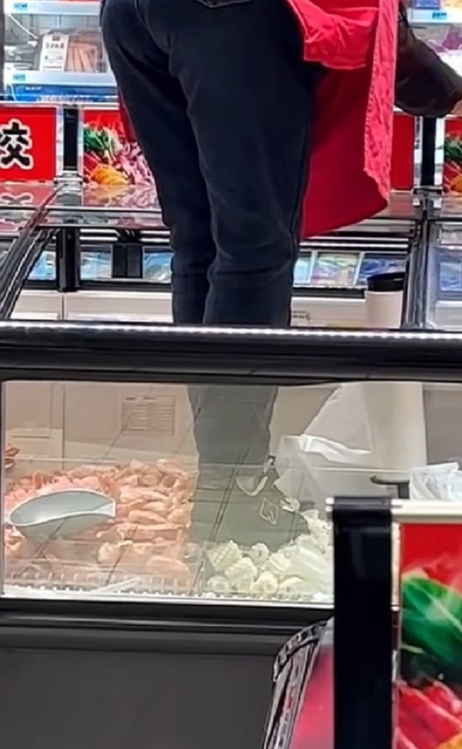 Nữ nhân viên ở siêu thị Trung Quốc khiến dân mạng phẫn nộ vì trèo cả giày vào tủ đông, đạp lên thực phẩm chỉ để dán tờ quảng cáo - Ảnh 3.
