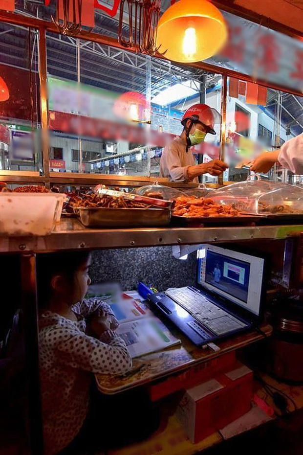 The picture of a child studying under the stall of his mother selling at the market is causing great emotion: All for the hope of the future - Photo 1.