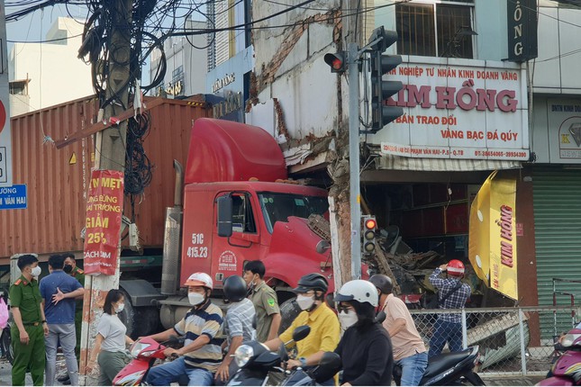 Container húc bay xe máy rồi lao vào tiệm vàng, 2 người thoát chết - Ảnh 1.