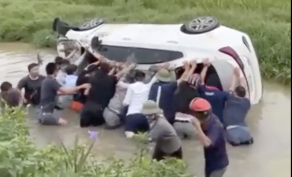 Hàng chục người giải cứu ô tô mất lái, lật ngửa dưới mương nước - Ảnh 1.