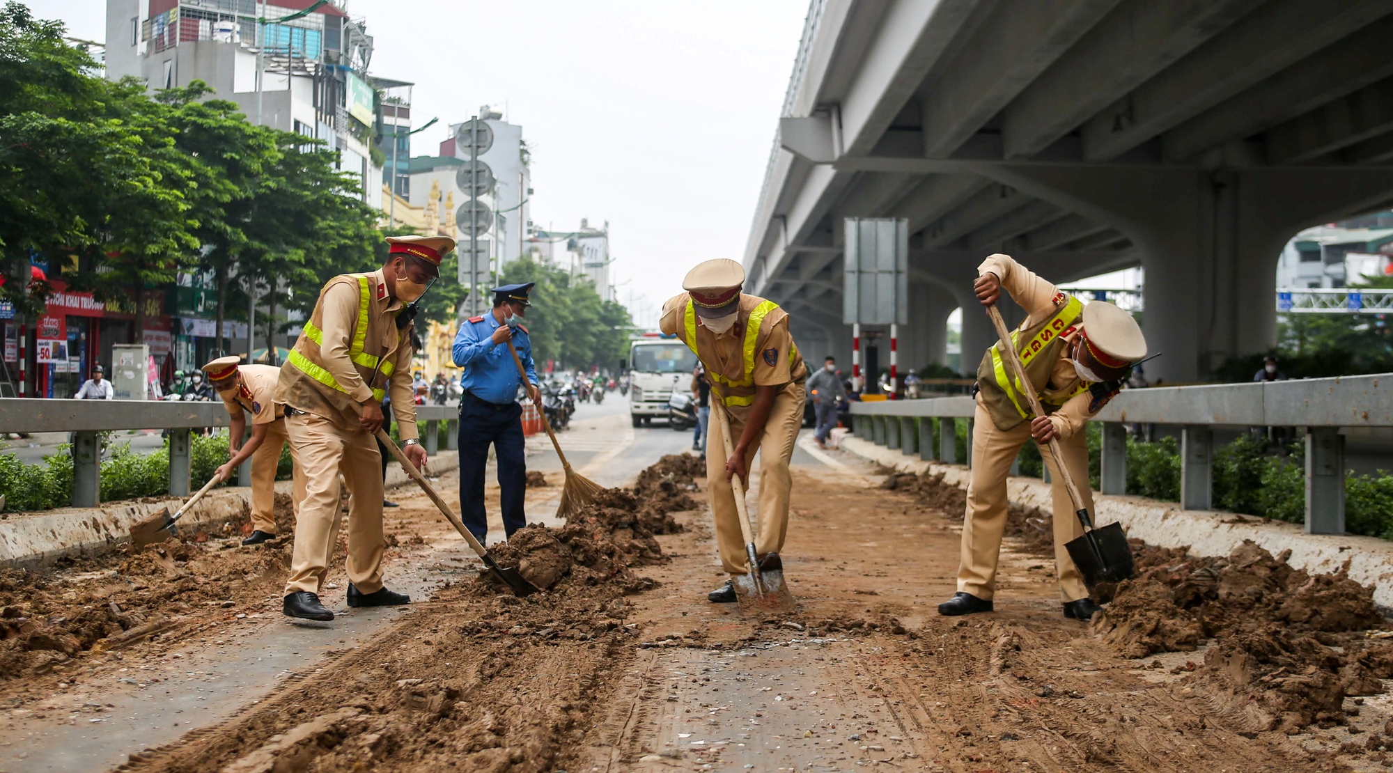 CSGT, TTGT dọn dẹp đất đá rơi vãi kín mặt đường dẫn lên cầu cạn Mai Dịch - Nam Thăng Long - Ảnh 3.