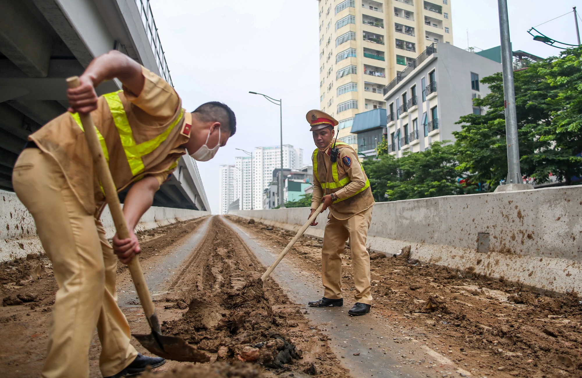 CSGT, TTGT dọn dẹp đất đá rơi vãi kín mặt đường dẫn lên cầu cạn Mai Dịch - Nam Thăng Long - Ảnh 4.