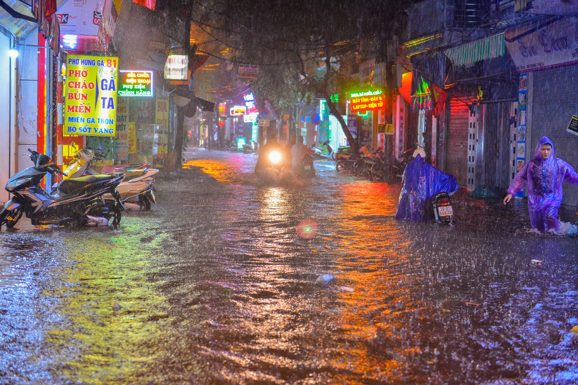 Mưa xối xả khiến đường Hà Nội chìm trong biển nước, sóng đánh đổ xe máy - Ảnh 1.
