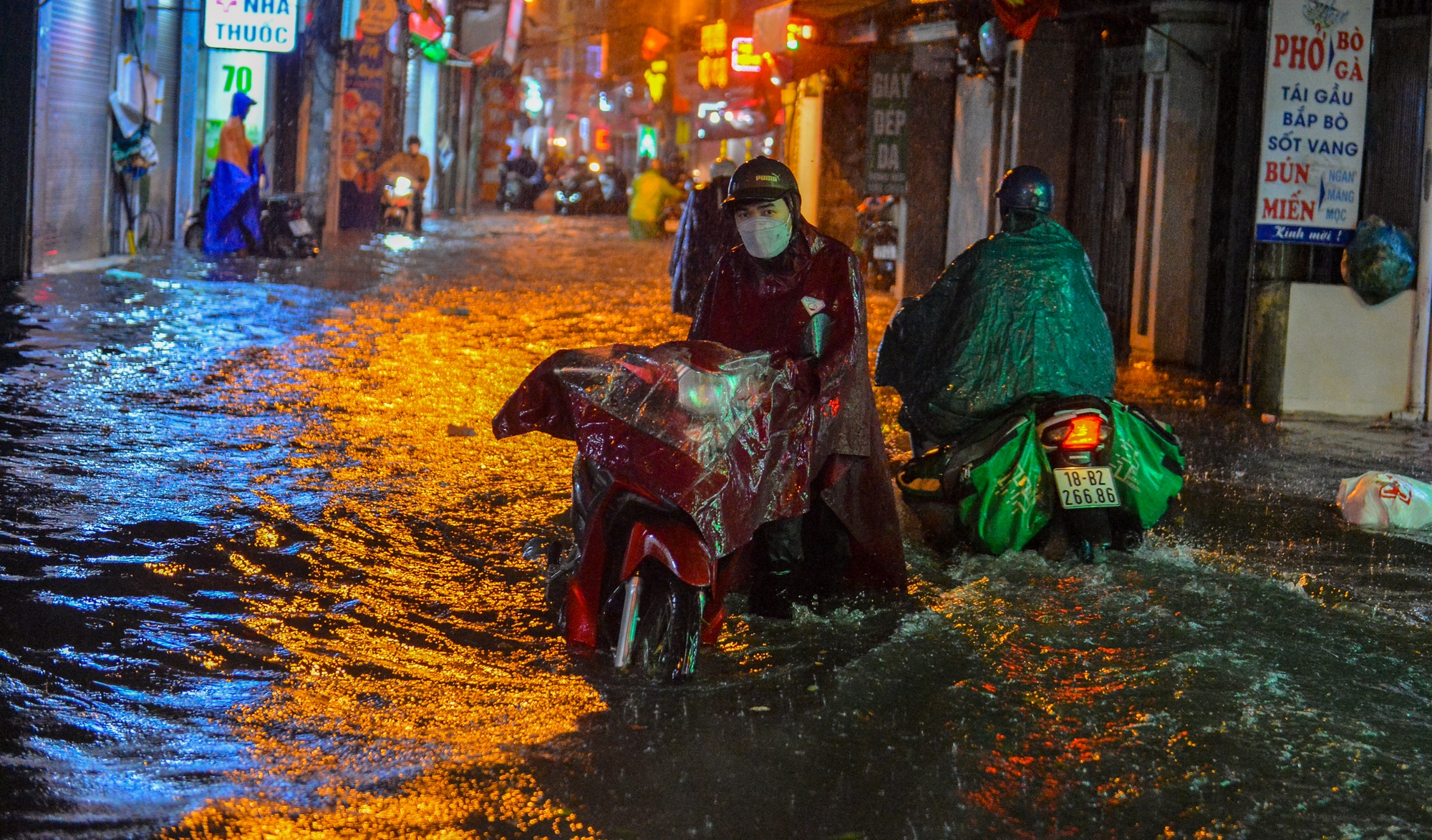 Mưa xối xả khiến đường Hà Nội chìm trong biển nước, sóng đánh đổ xe máy - Ảnh 2.