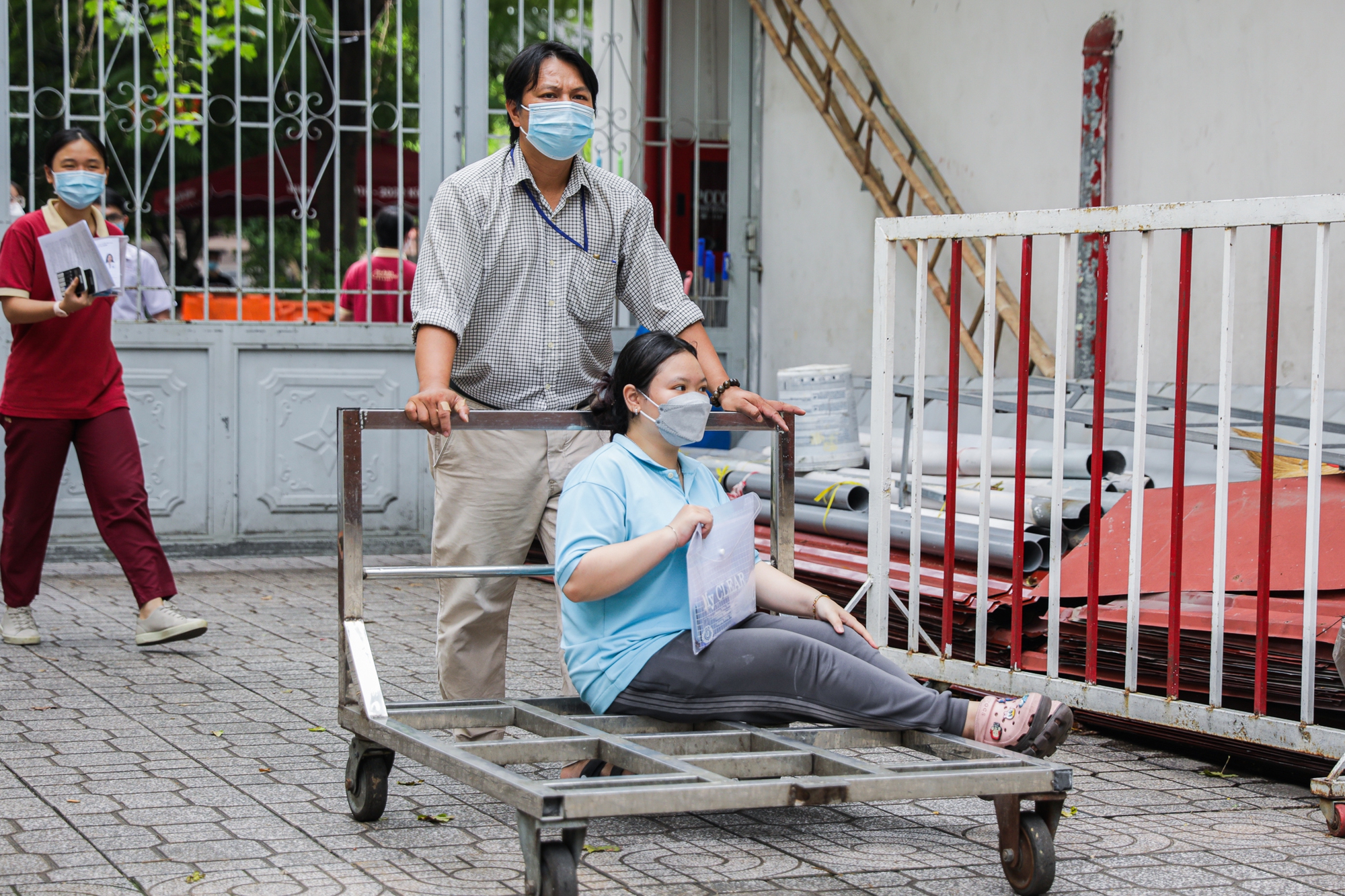 Thí sinh đến phòng thi bằng xe đẩy hàng, tình nguyện viên tiếp sức bằng 4 thứ tiếng - Ảnh 1.