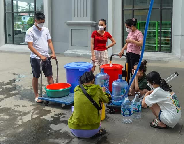 Hà Nội: Người dân mang xô, thùng xếp hàng giữa trưa đợi lấy nước - Ảnh 3.
