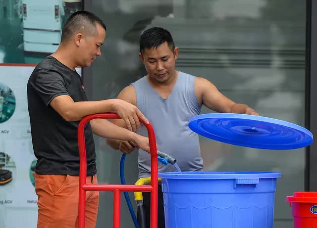 Hà Nội: Người dân mang xô, thùng xếp hàng giữa trưa đợi lấy nước - Ảnh 10.