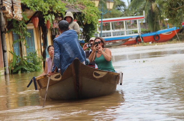 Hội An ngập sâu, du khách thuê ghe ra phố sau bão - Ảnh 4.