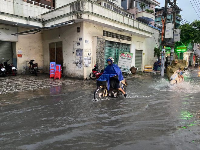 Người dân TP.HCM vật vã trong nước ngập và kẹt xe sau cơn mưa lớn - Ảnh 9.