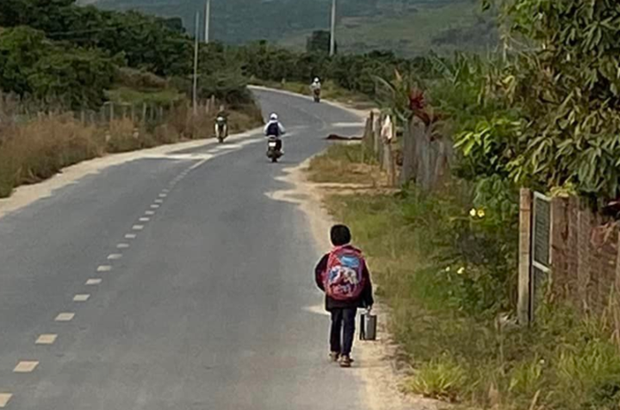  Bé trai đi bộ đến trường được quá giang gợi lại ký ức của nhiều người - Ảnh 1.