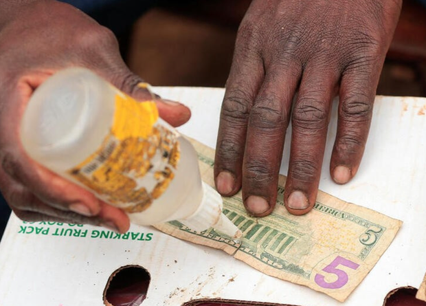 Sống sót từ nghề vá tiền cũ để giao dịch tại chợ đen ở Zimbabwe - Ảnh 1.