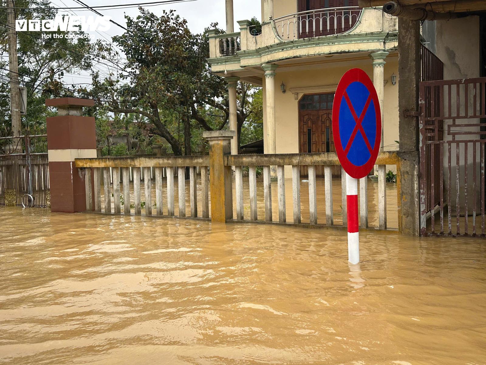 Nước lũ vây tứ phía, người dân Quảng Bình đứng trên nóc nhà nhận hàng cứu trợ - Ảnh 11.