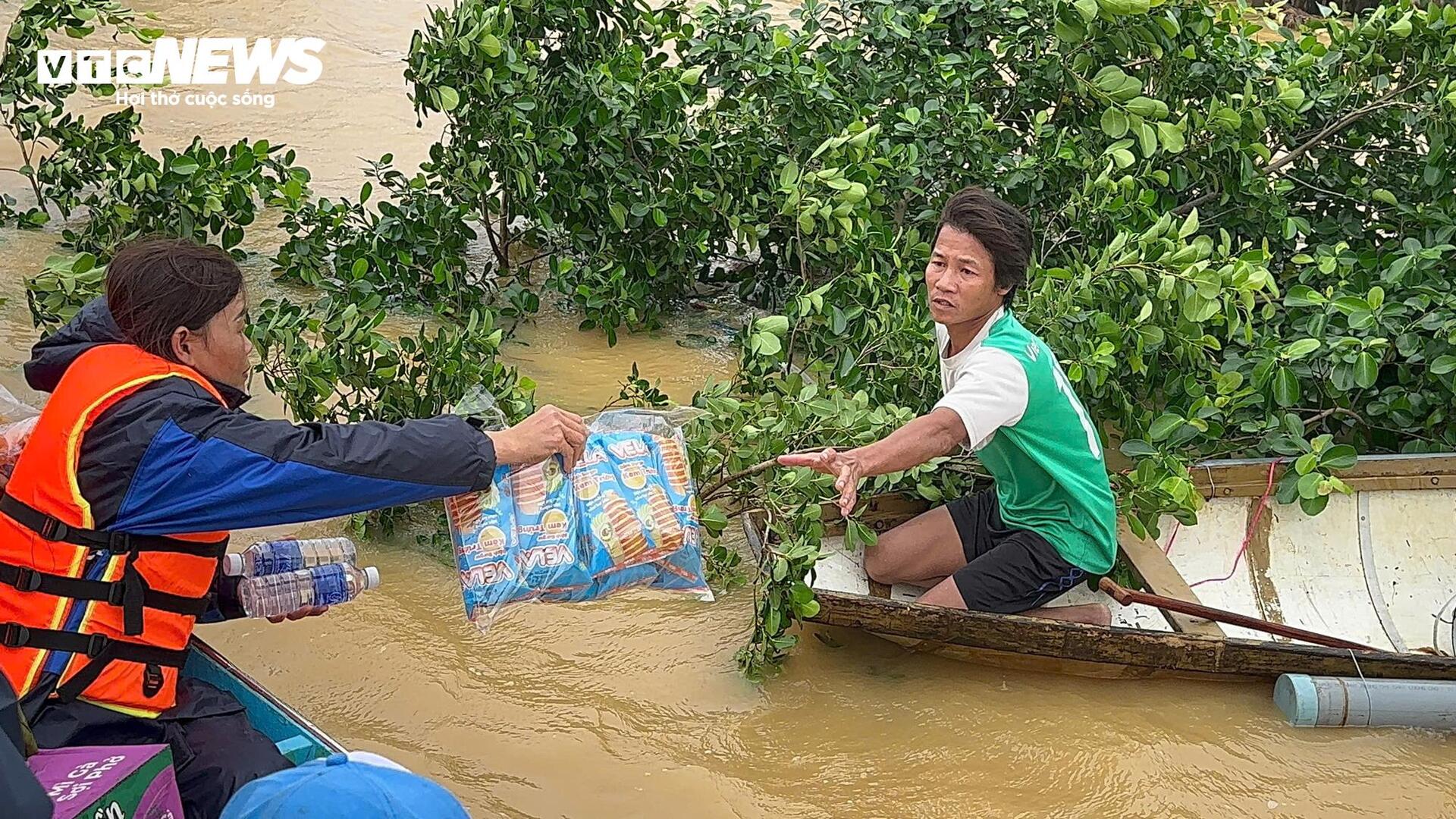 Nước lũ vây tứ phía, người dân Quảng Bình đứng trên nóc nhà nhận hàng cứu trợ - Ảnh 8.