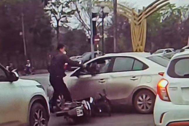 Va chạm giao thông, người đàn ông dùng mũ bảo hiểm đập vỡ kính ô tô- Ảnh 1.