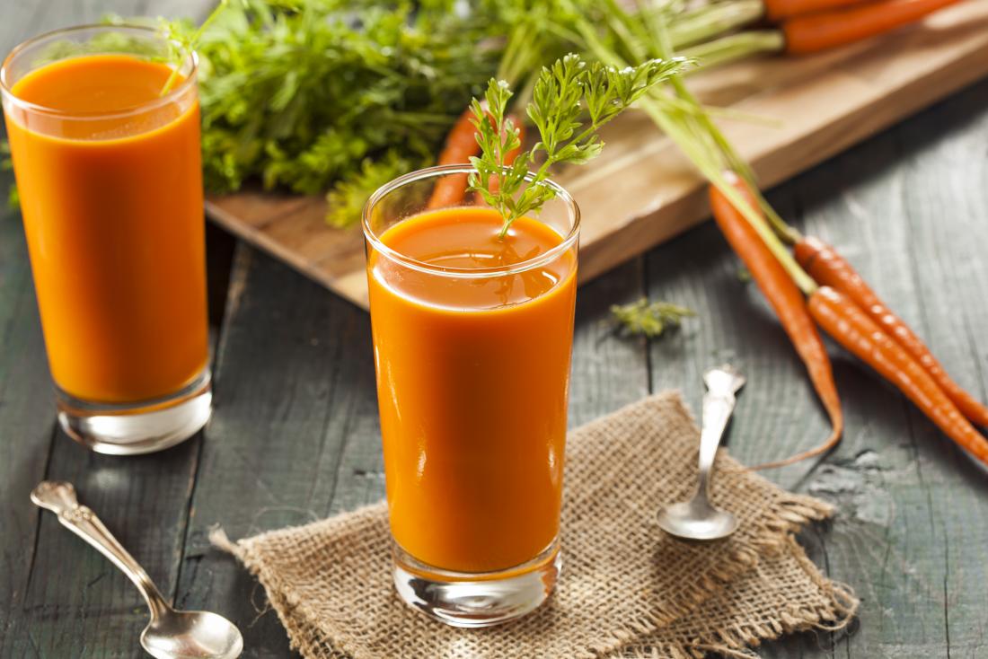 carrot-juice-in-glasses-next-to-raw-carrots-on-chopping-board.jpg