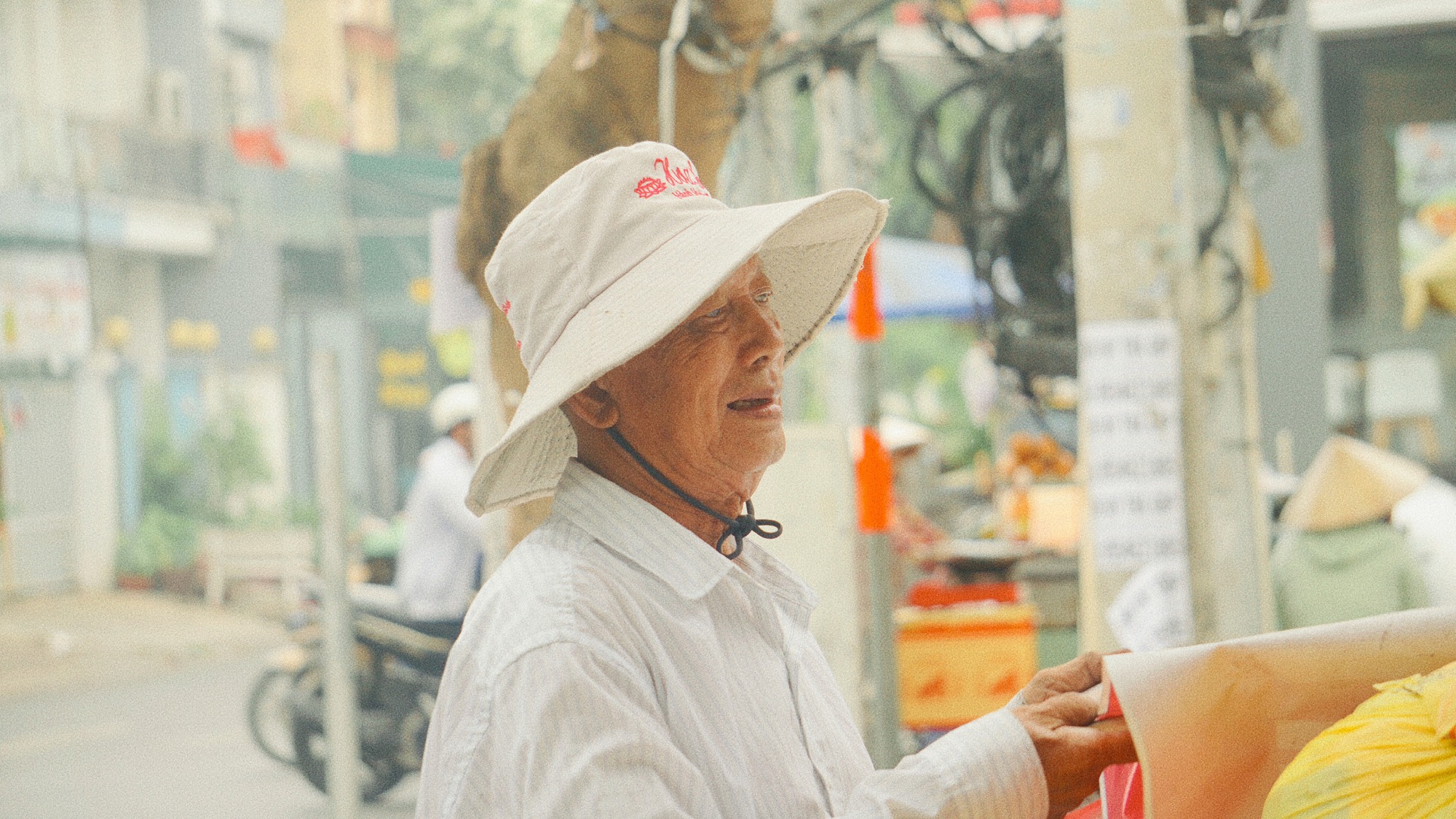 Cụ ông gần 90 tuổi đội mưa bán sách cũ ở vỉa hè Sài Gòn: "Lần nào thấy người trẻ đến mua sách là tôi vui lắm"- Ảnh 1.