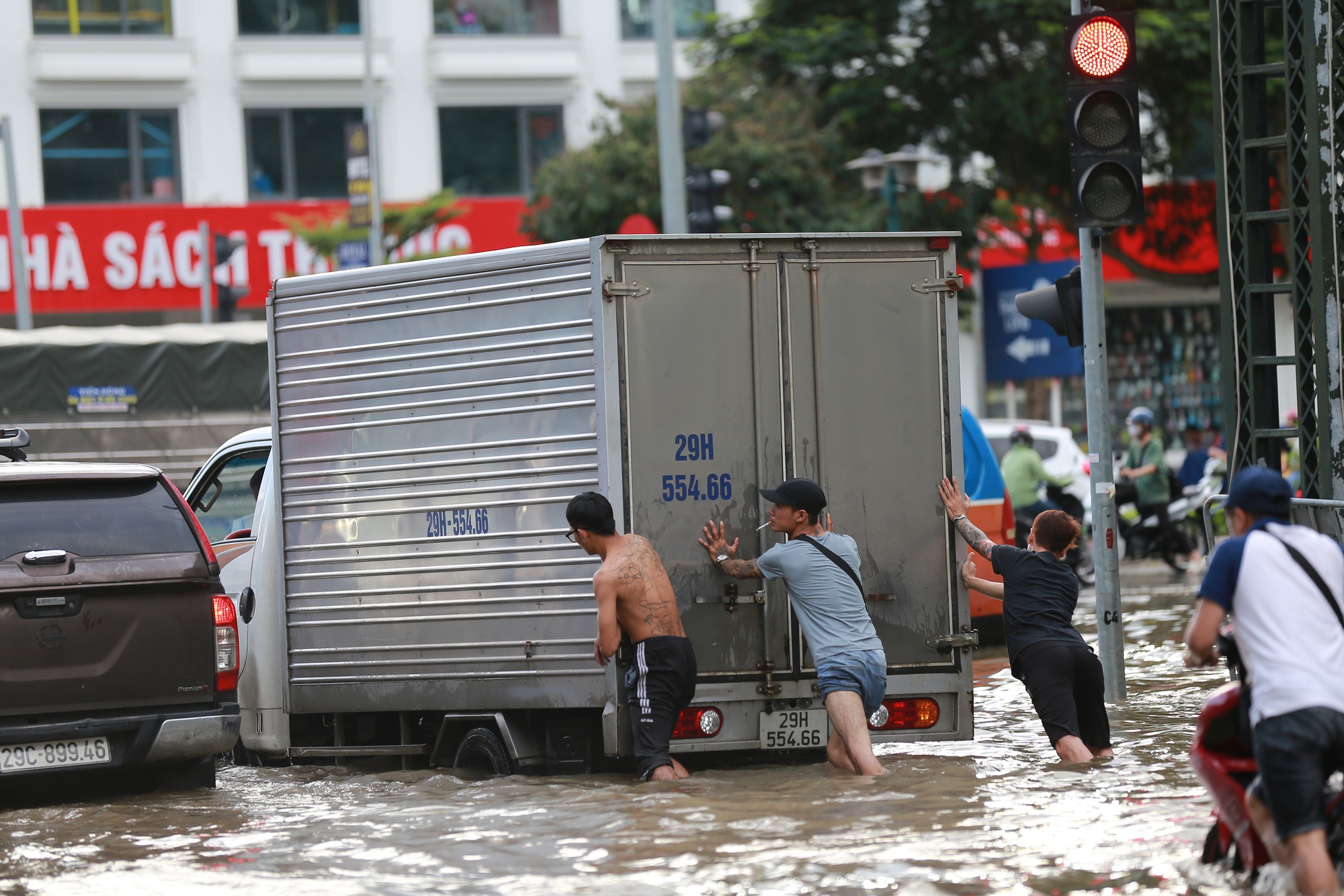 Trời hửng nắng, nhiều tuyến đường ở Hà Nội vẫn ngập sâu, người dân dùng tấm chắn để ngăn nước tràn vào nhà- Ảnh 15.