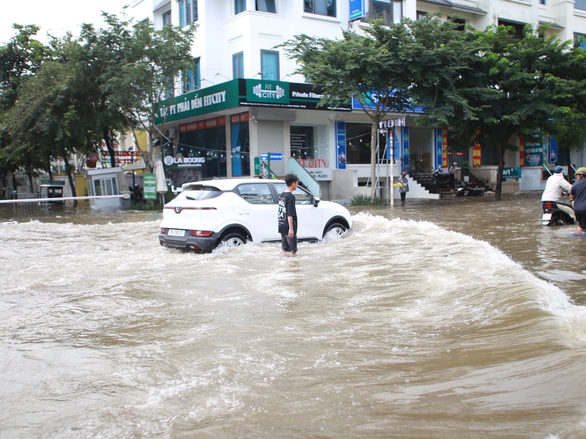 Trời hửng nắng, nhiều tuyến đường ở Hà Nội vẫn ngập sâu, người dân dùng tấm chắn để ngăn nước tràn vào nhà- Ảnh 12.