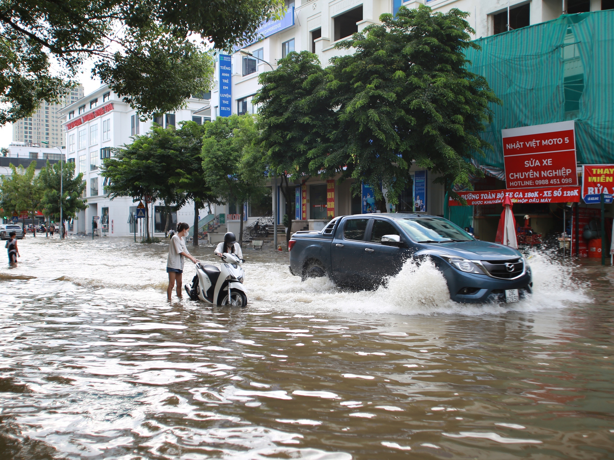 Trời hửng nắng, nhiều tuyến đường ở Hà Nội vẫn ngập sâu, người dân dùng tấm chắn để ngăn nước tràn vào nhà- Ảnh 13.