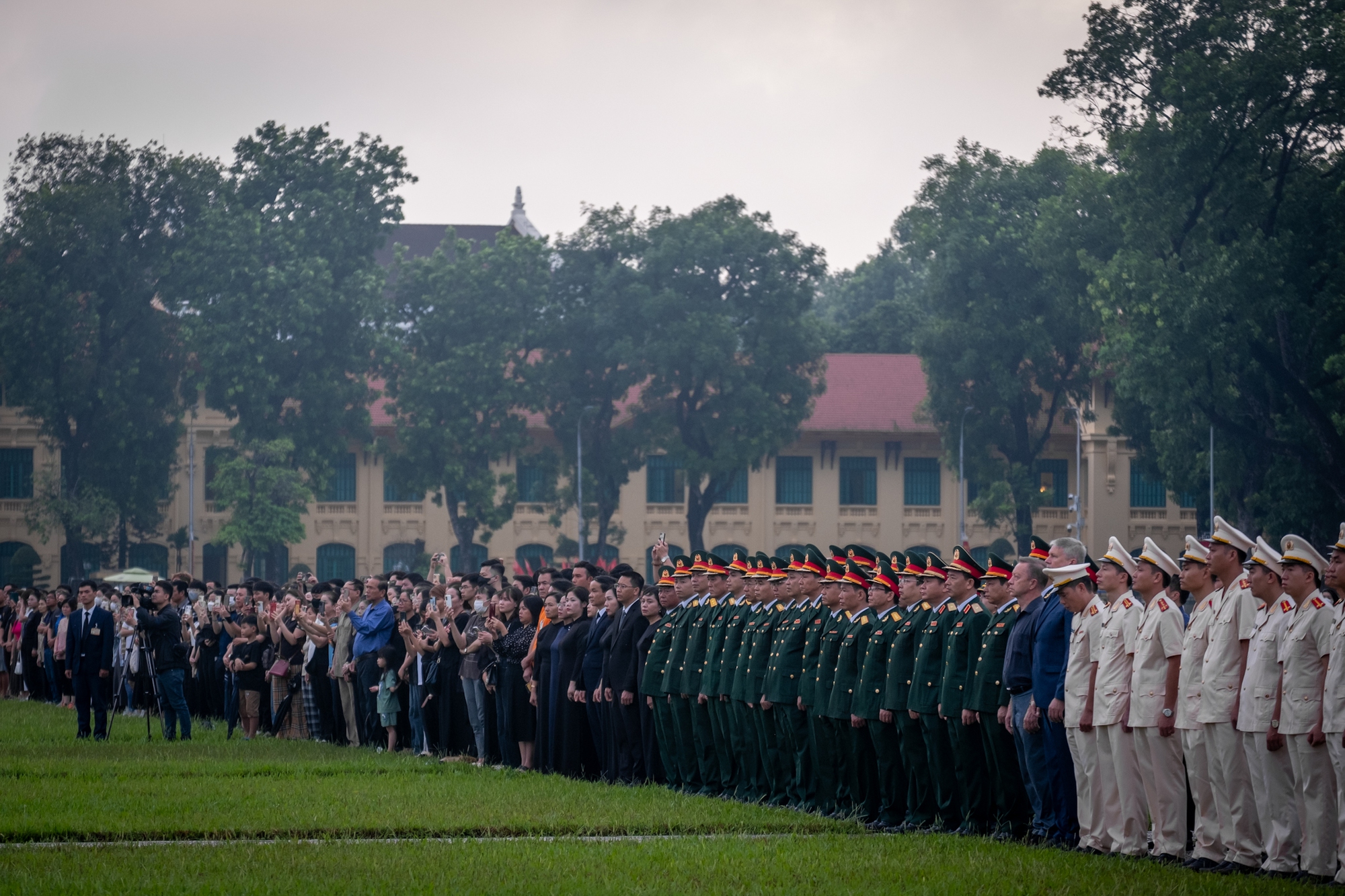 Người dân đứng trang nghiêm, xúc động chứng kiến Lễ thượng cờ rủ Quốc tang Tổng Bí thư Nguyễn Phú Trọng- Ảnh 8.