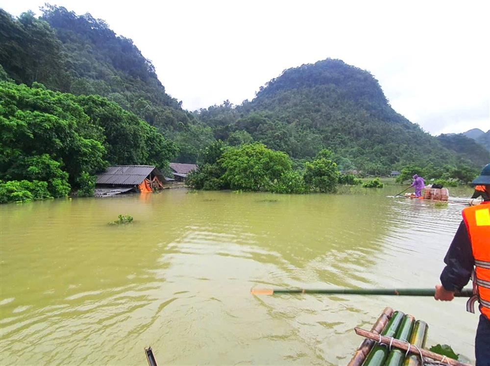 Cảm động hình ảnh công an chèo bè 4 tiếng qua vùng nguy hiểm để cứu thai phụ bị cô lập trong nước lũ- Ảnh 1.