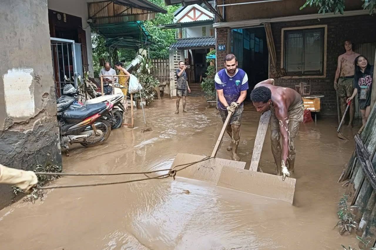 Thấy người phụ nữ Việt kêu "giúp tôi với", đoàn khách Tây lập tức lội bùn, xắn tay dọn dẹp sau lũ- Ảnh 1.