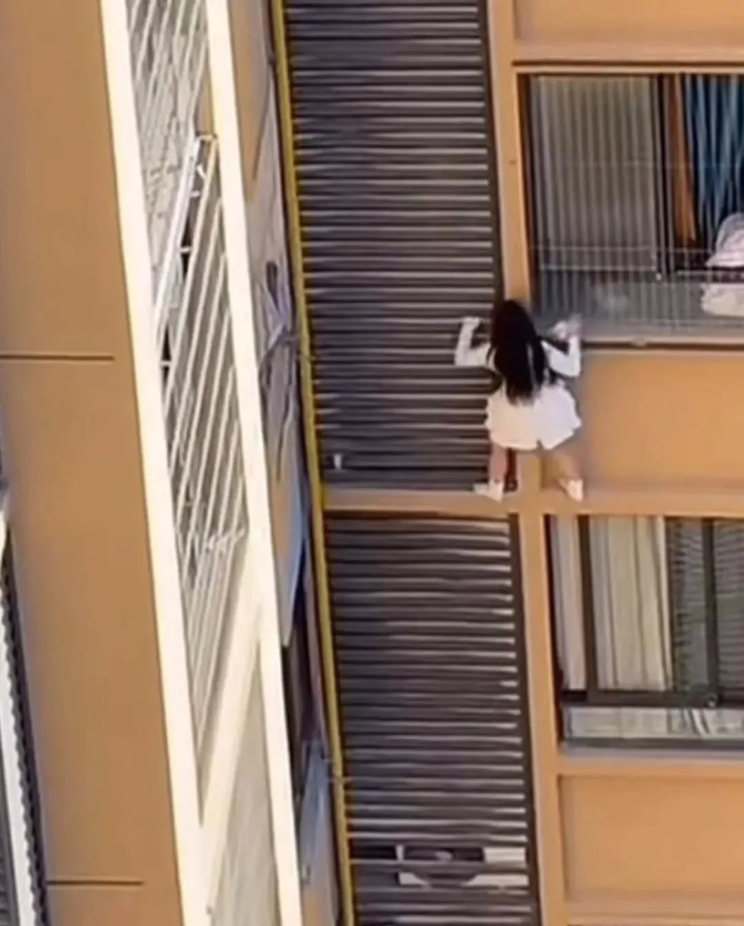 Clip cô gái trèo ra khỏi cửa sổ chung cư, bùng nổ tranh cãi khi zoom cận phát hiện người đàn ông cởi trần- Ảnh 1.